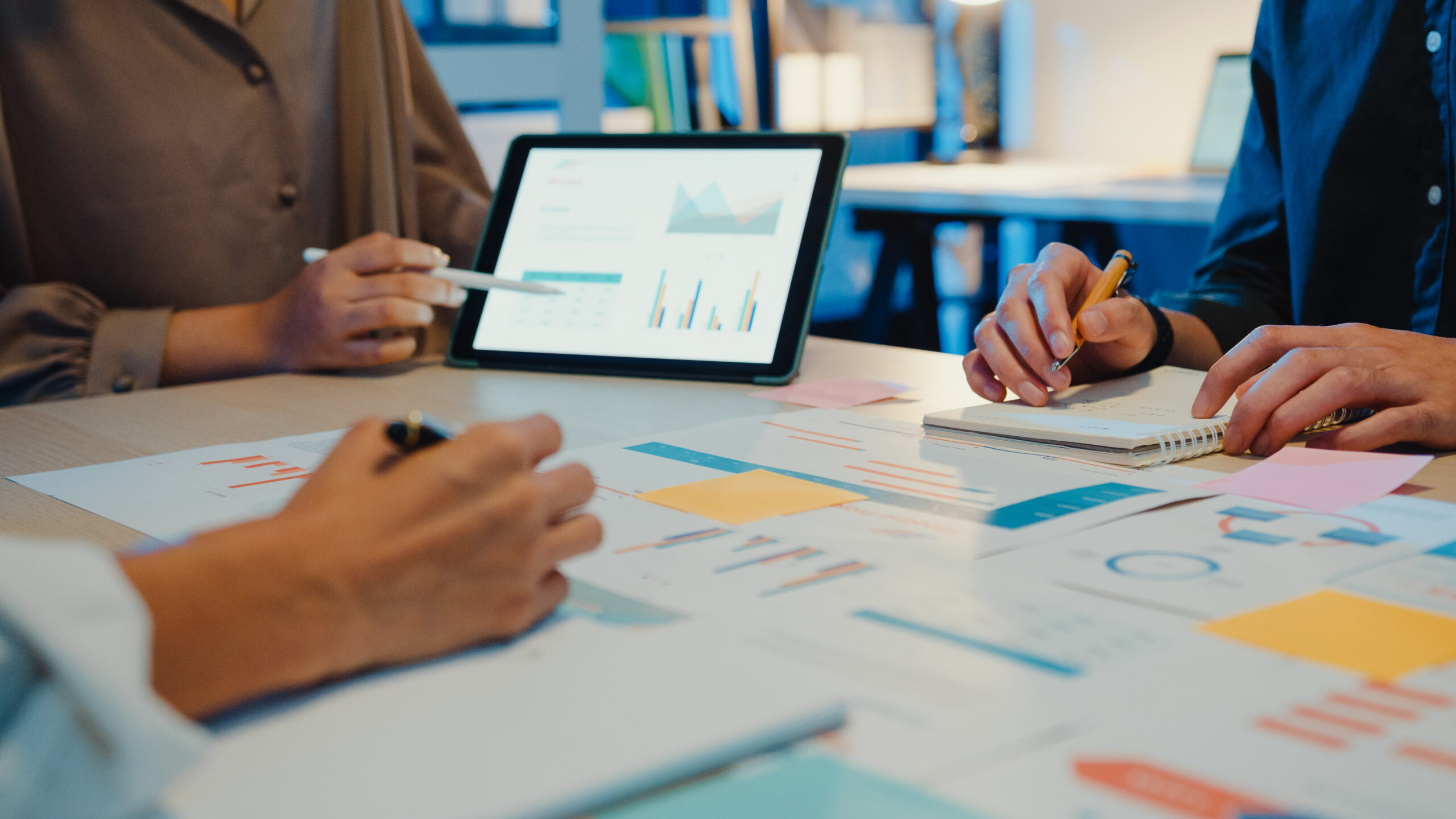 Close-up asia business people meeting plan analysis statistics brainstorm and header of team hold tablet pointing graph chart and employee take note. Finance strategy statistics success concept.